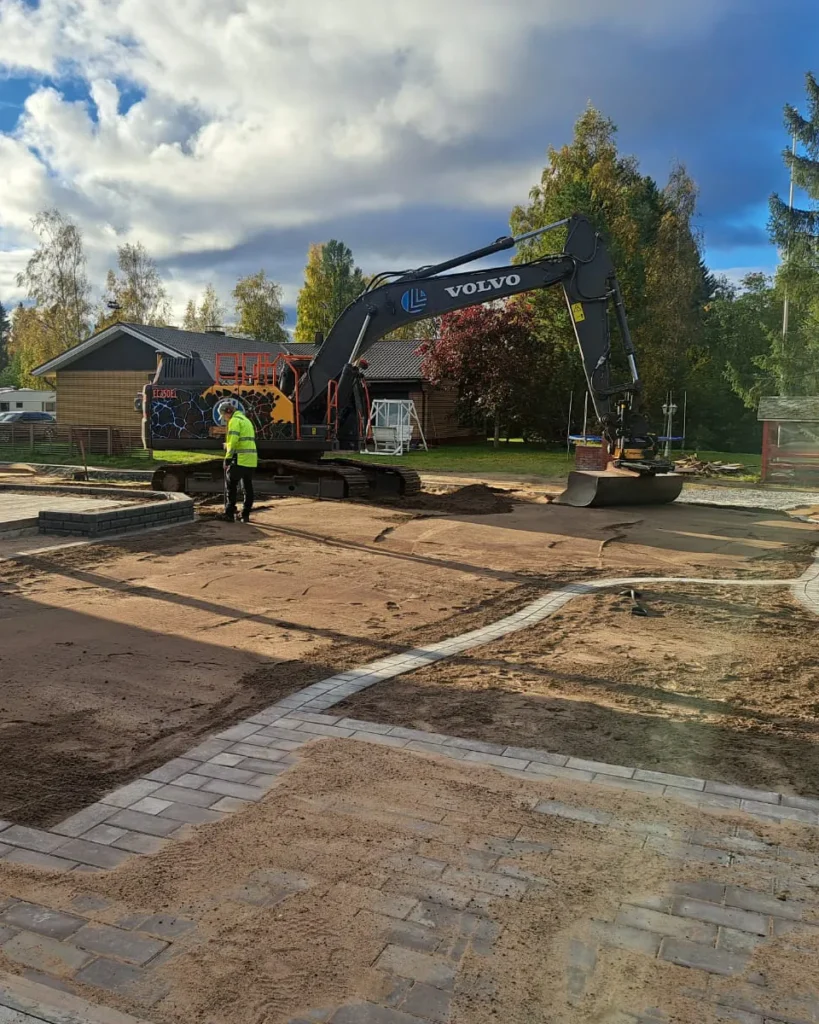 Kuljetus Laurikkalan kaivinkone tasoittaa omakotitalon pihamaata kesällä